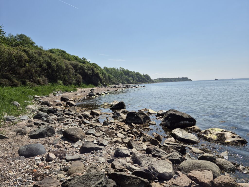 Stenstrand och klippa.